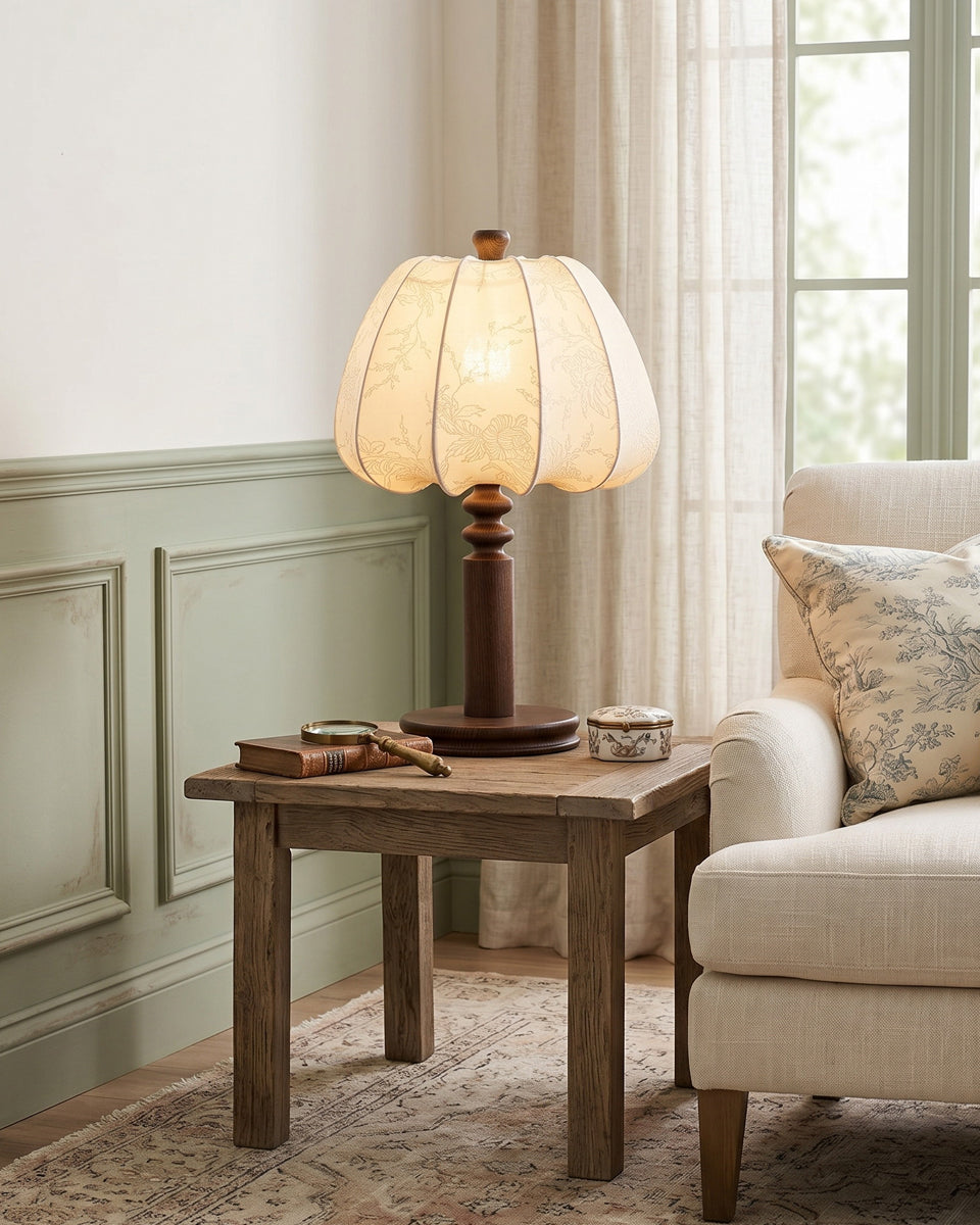 Fabric table lamp glowing beside a linen armchair